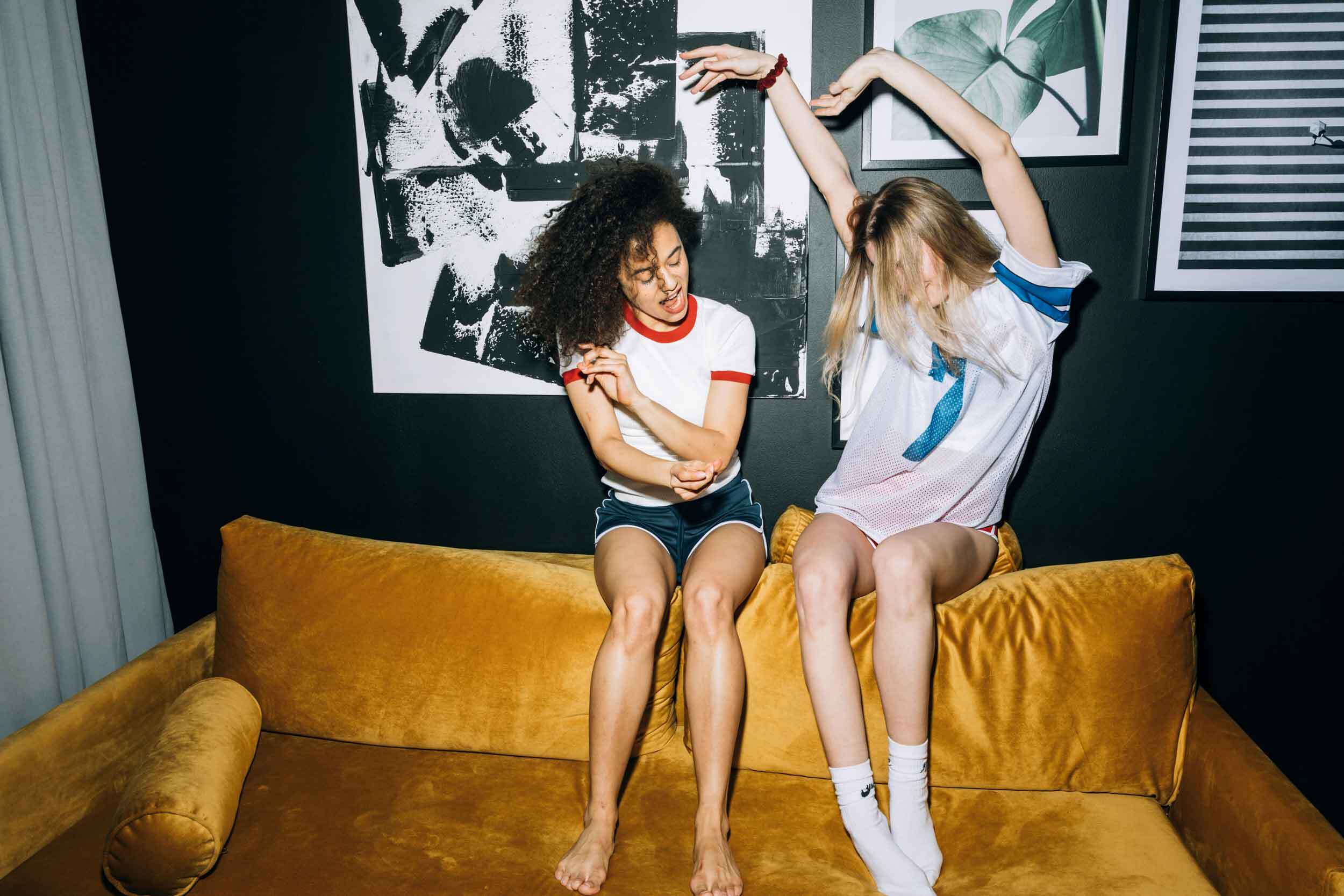 girls sitting on the top of yellow velvet couch