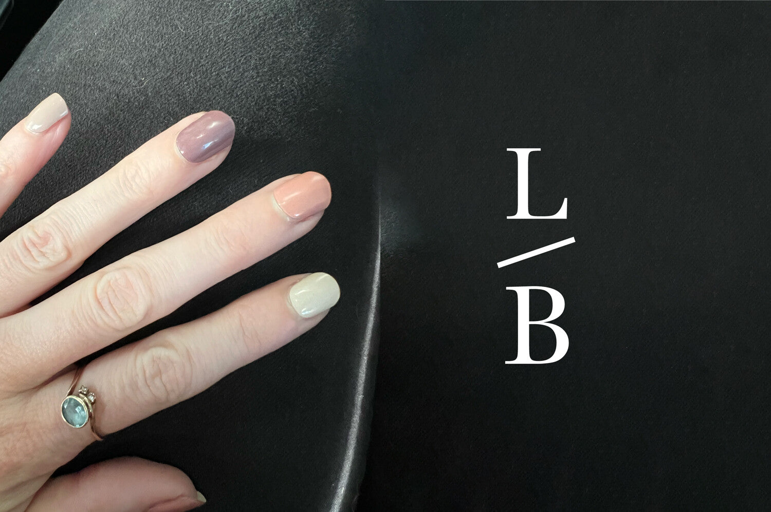 mixed berry semi cured gel nails on hands with black background, ring on finger