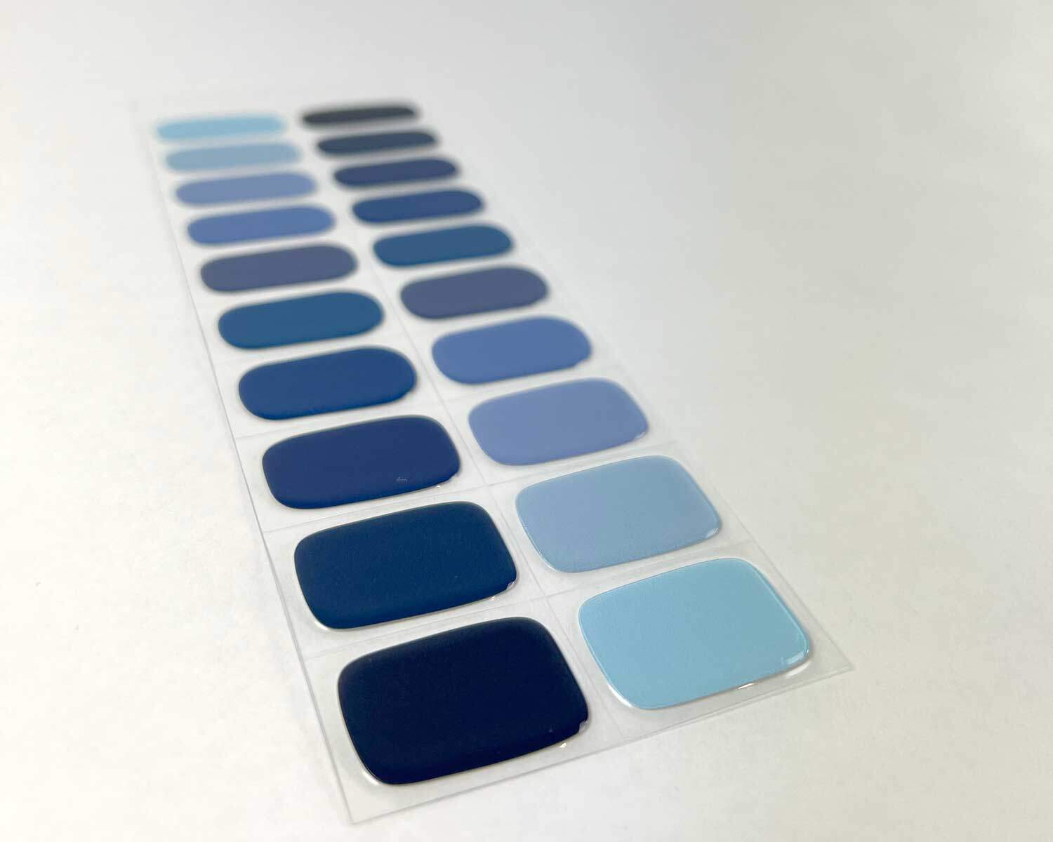 Blue Mixed semi-cured gel nails on angle zoomed in on white background