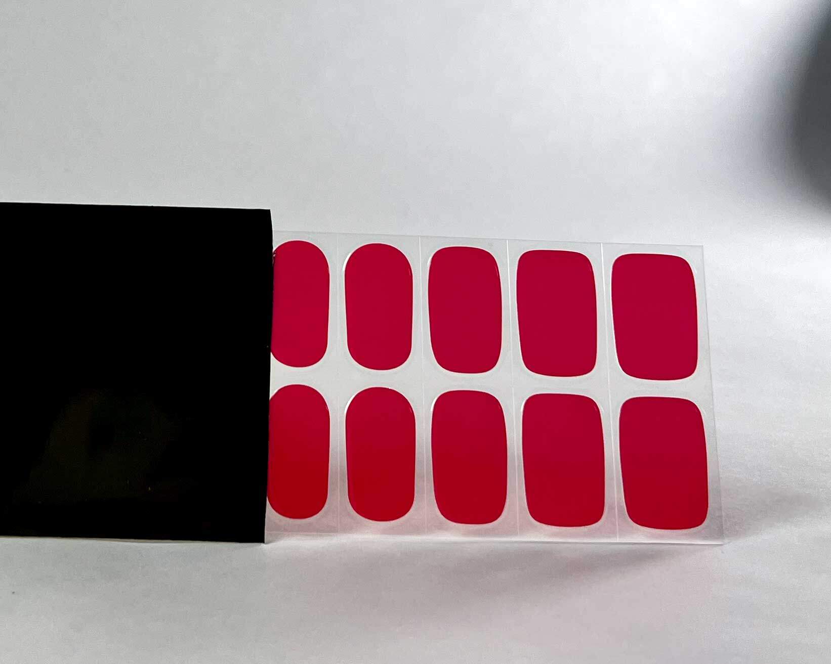 Cherry Red semi-cured gel nails in black light sensitive strip with la-bek uv lamp box in the background