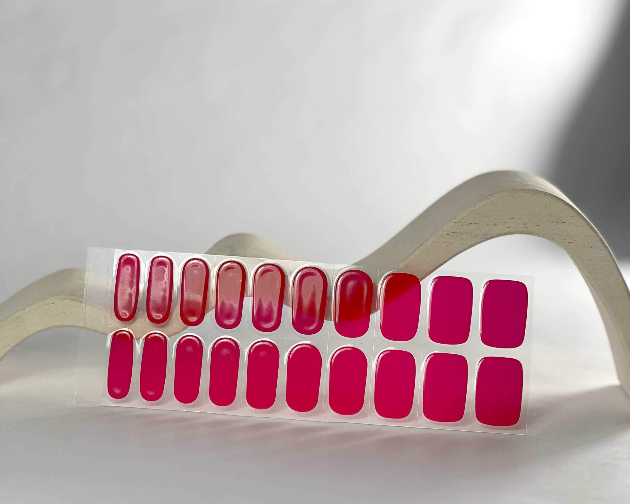 Cherry Red semi-cured gel nails in mockup to show product against white wave wooden block