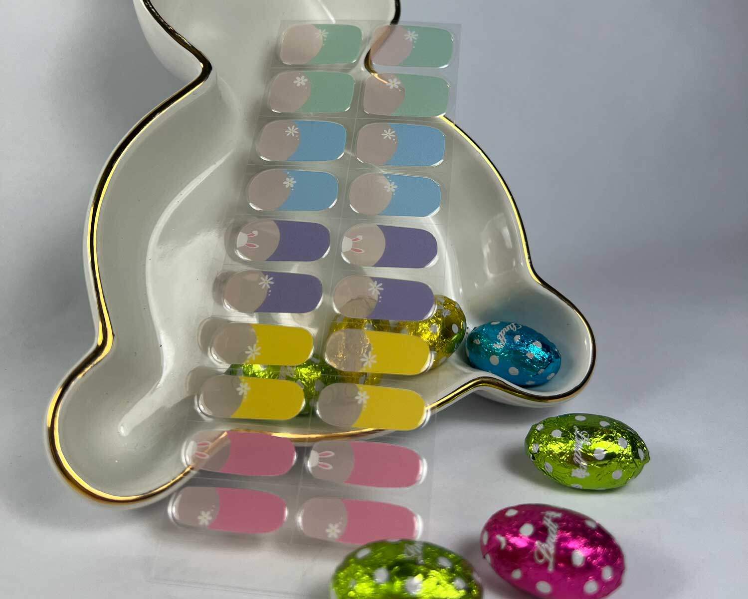 French bunny rainbow semi-cured gel nails in mockup to show product against bunny plate with easter eggs