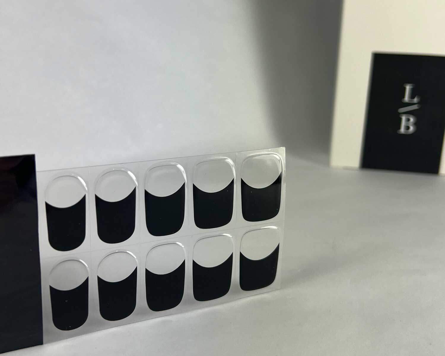 French night black semi-cured gel nails in black light sensitive strip with la-bek uv lamp box in the background