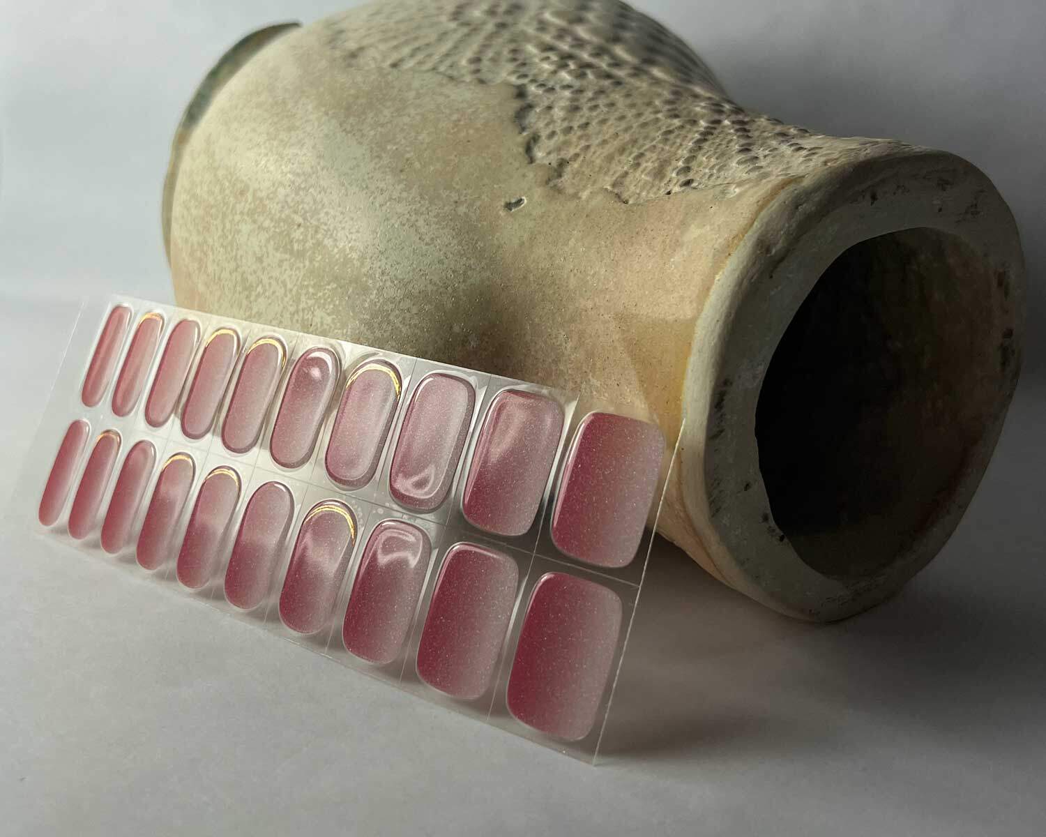 Golden sunset pink semi-cured gel nails in mockup to show product against ceramic textured head