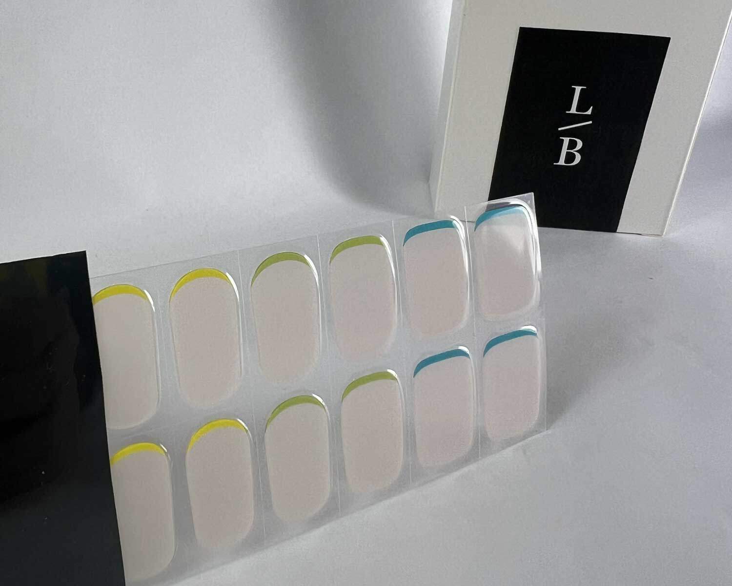 hidden-rainbow-semi-cured-gel-nail-black-strip Hidden Rainbow silver semi-cured gel nails in black light sensitive strip with la-bek uv lamp box in the background