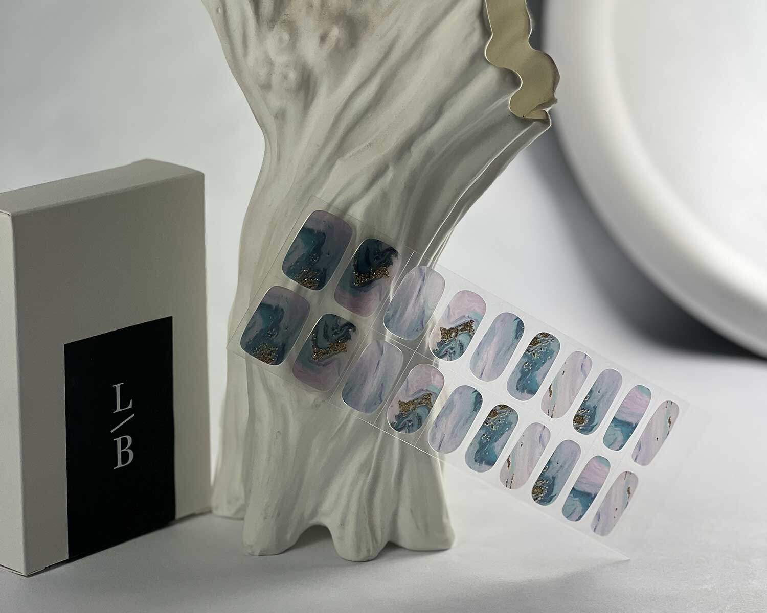 Opal Glitter Gold semi-cured gel nails in mockup to show product against white textured tree with la-bek uv lamp in the background