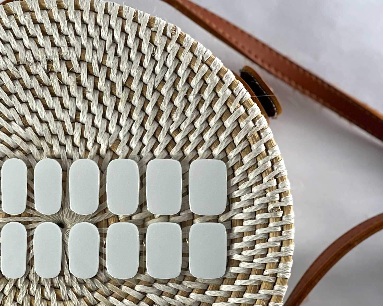 Pure White semi-cured gel nails in mockup to show product against textured handbag