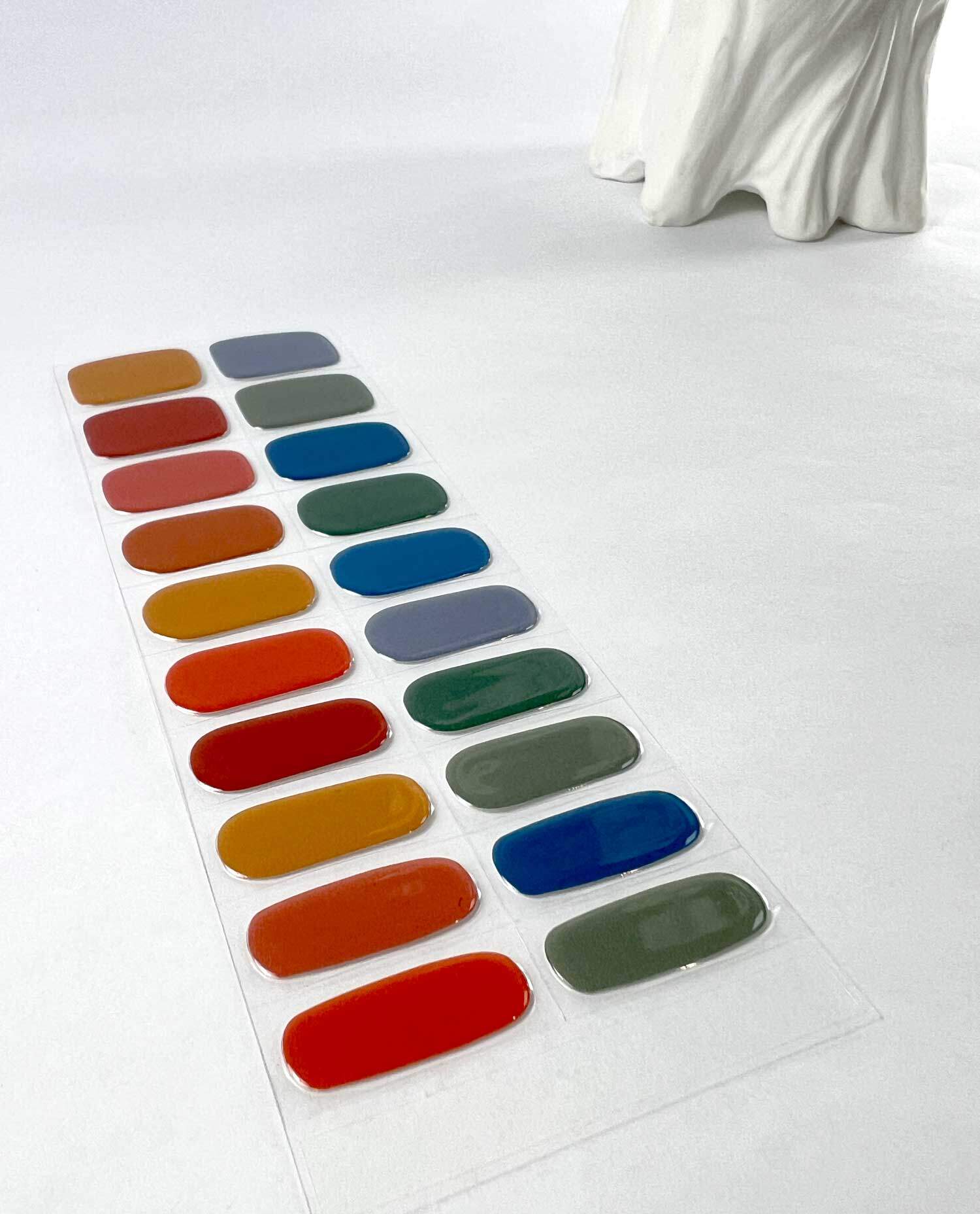 Rainbow dreams reds yellows blues semi-cured gel nails on angle zoomed in on white background