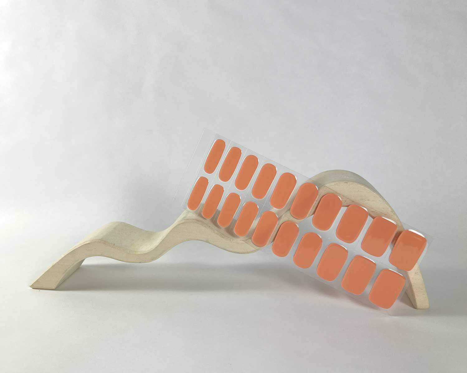 semi-cured-Gel-Nail-Sticker-classic-coral-mock2 Classic coral orange semi-cured gel nails in mockup to show product against white wave wooden block
