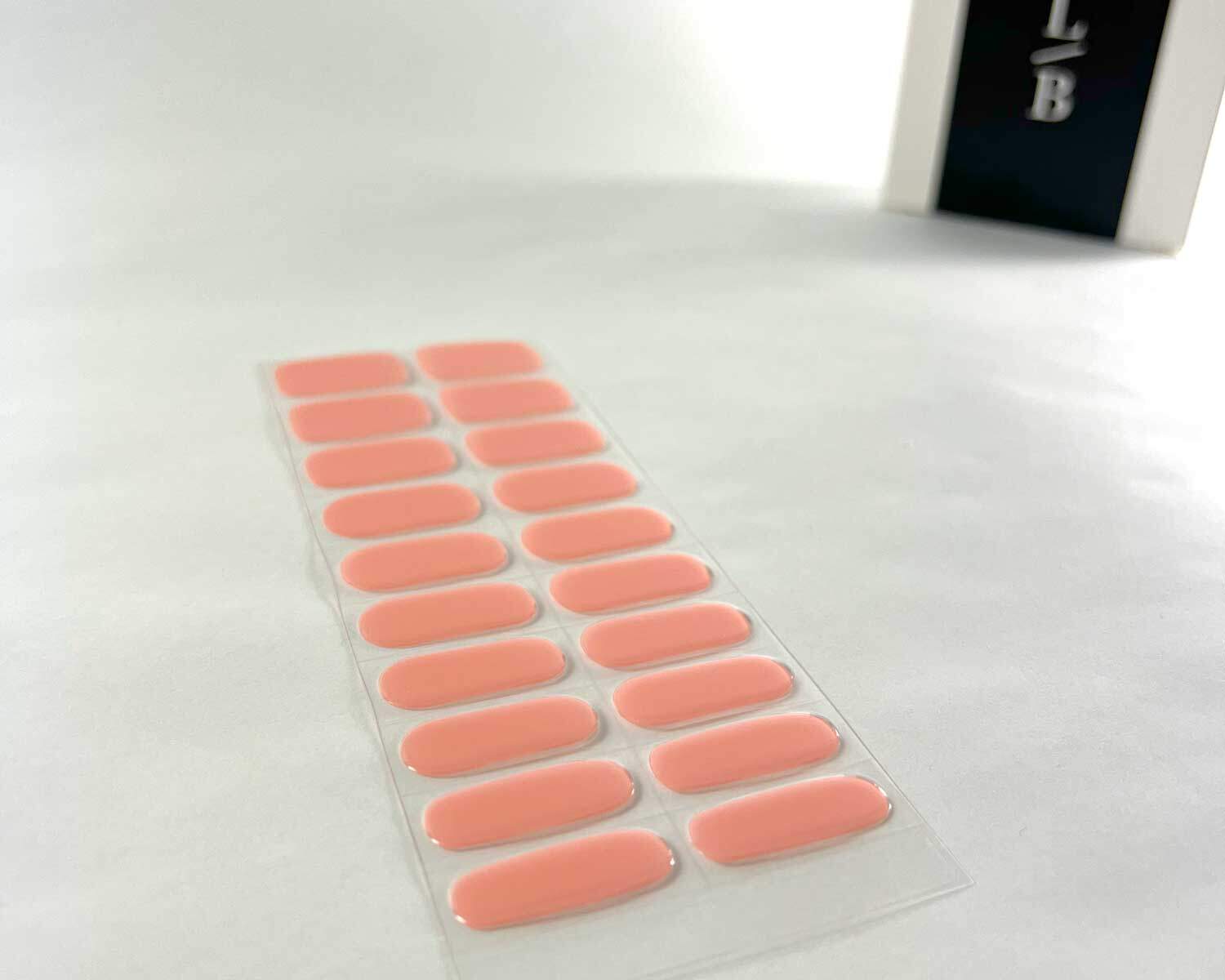 semi-cured-Gel-Nail-Sticker-strawberry-sunday-angle Strawberry Sunday pink semi-cured gel nails on angle zoomed in on white background with la-bek uv lamp box in the background