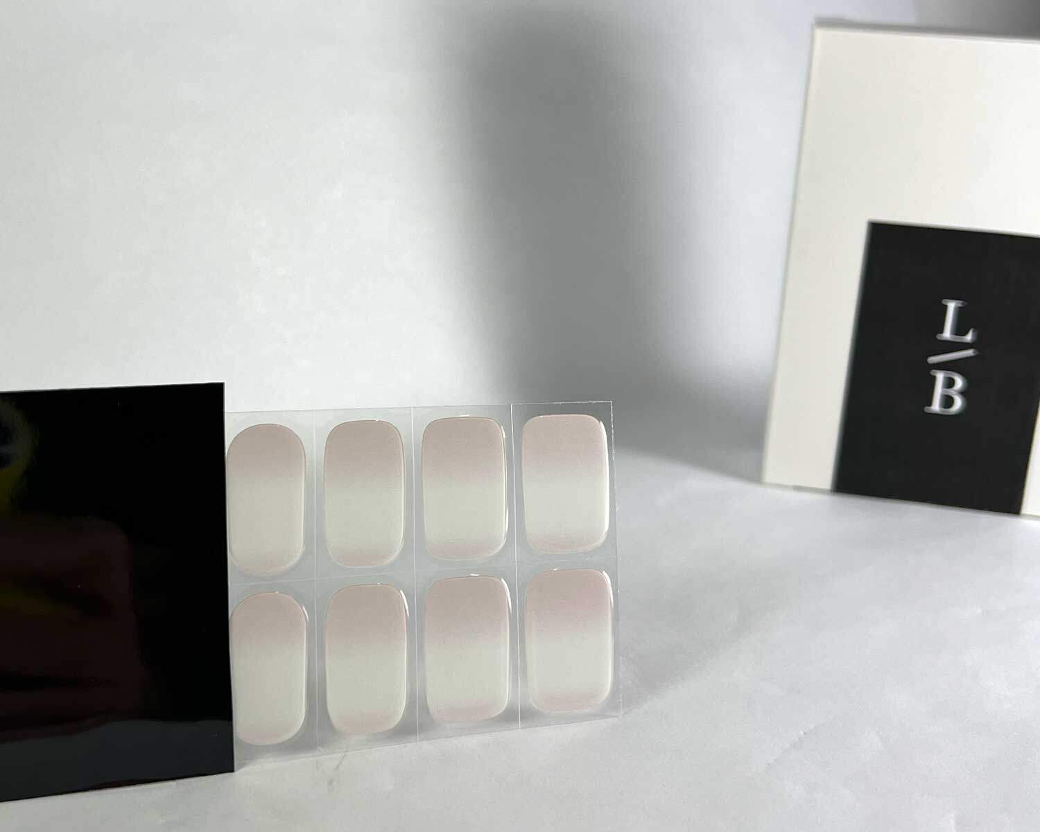 Pink Tide semi-cured gel nails in black light sensitive strip with la-bek uv lamp box in the background