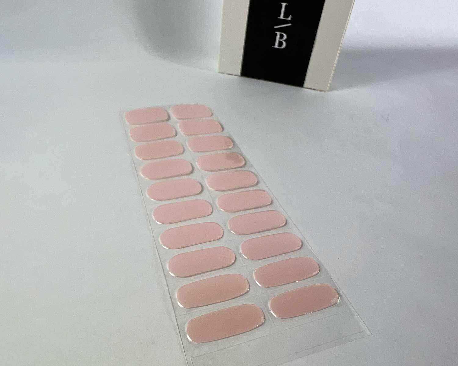 Pink Rose Garden semi-cured gel nails on angle zoomed in on white background with la-bek uv lamp box in the background