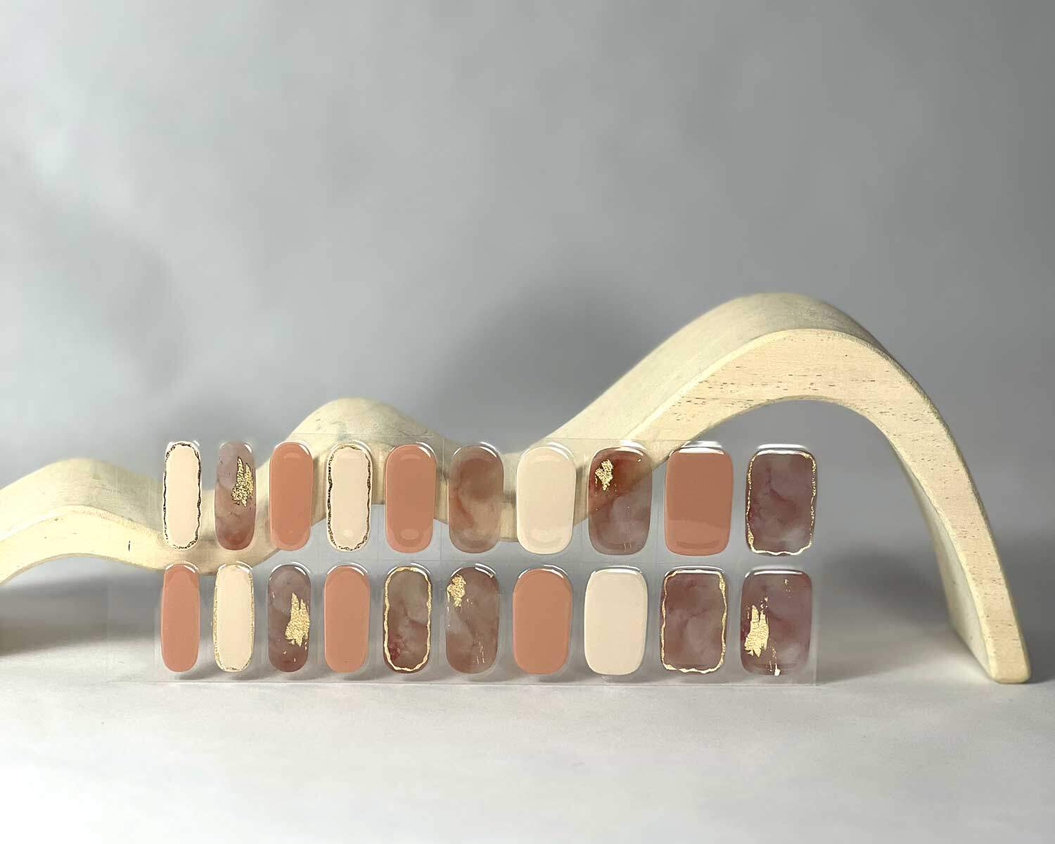 Gold Digger semi-cured gel nails in mockup to show product against white wave wooden block