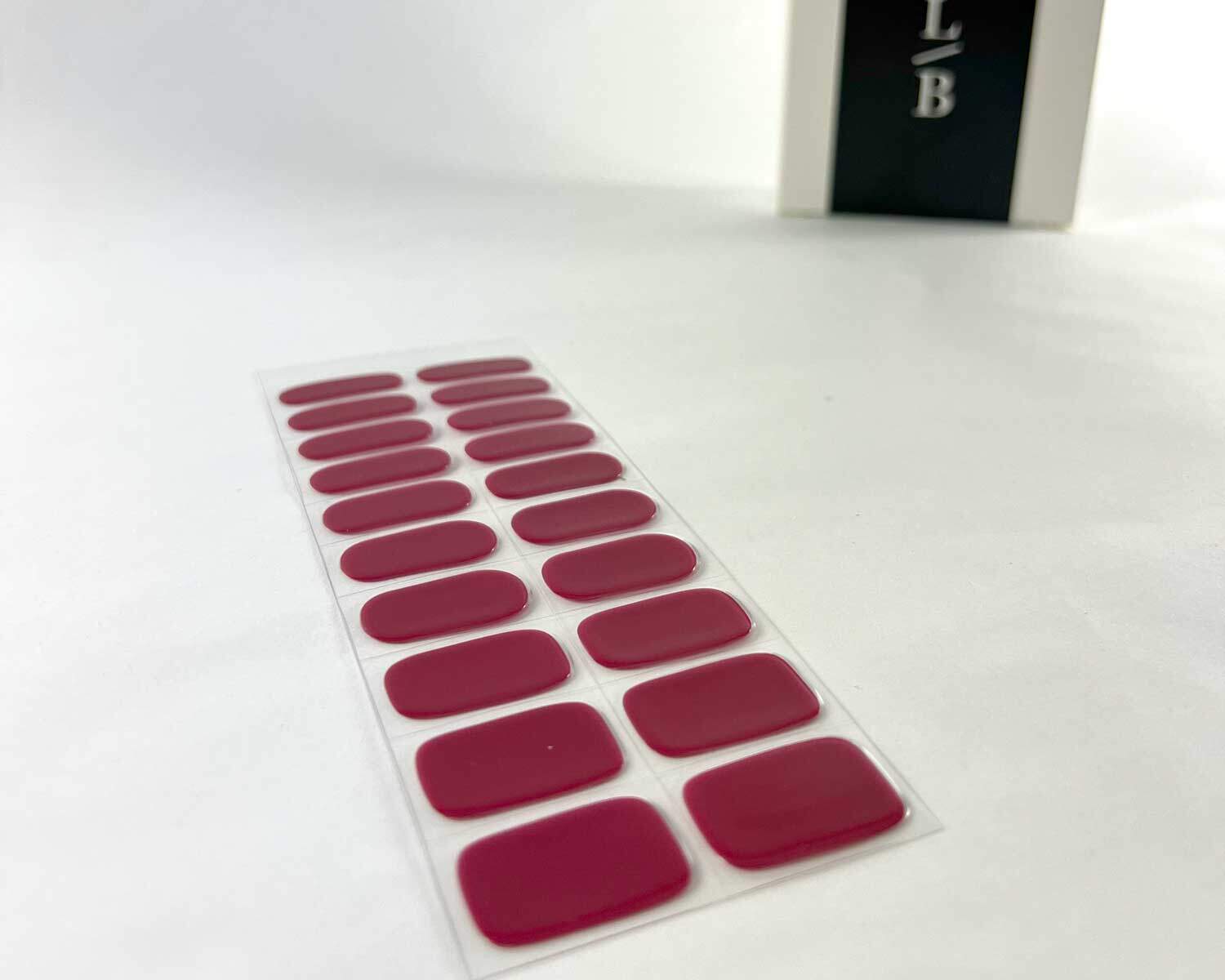 magenta moment semi cured gel nails on an angle with white background and la-bek uv lamp