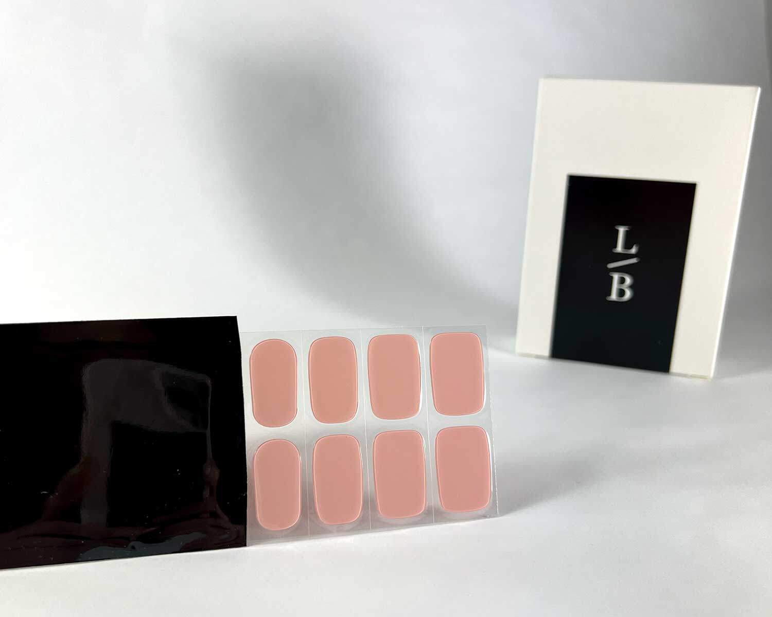 semi-cured-Gel-Nail-Sticker-pink-marshmellow-black-strip pink marshmallow semi-cured gel nails in black light sensitive strip with la-bek uv lamp box in the background