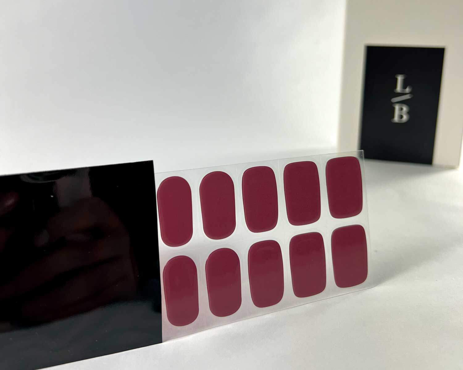 plum jam semi cured gel nails in black light sensitive strip with la-bek uv lamp box in the background