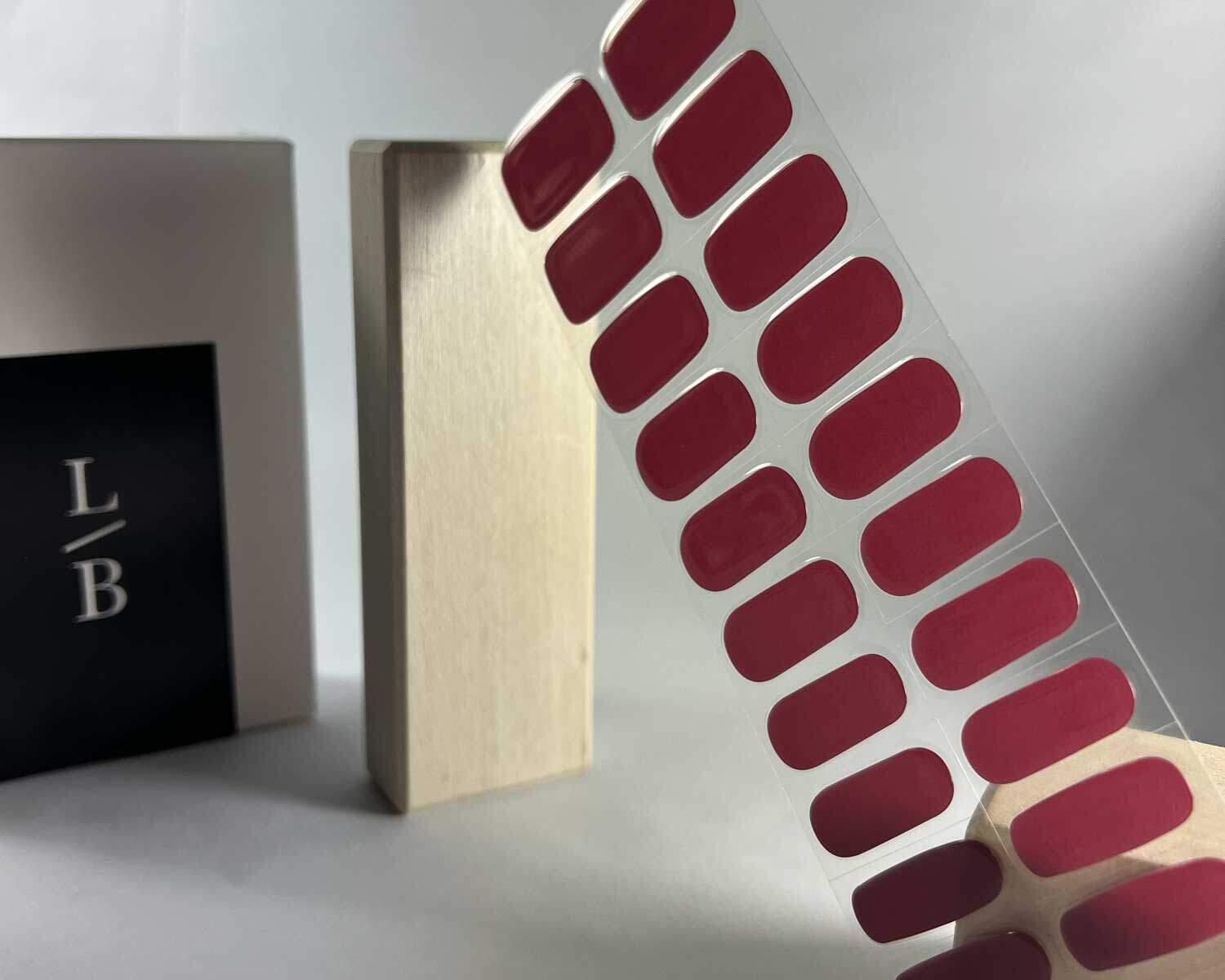 plum jam semi cured gel nails in mockup to show product against wooden block with la-bek uv lamp in the background