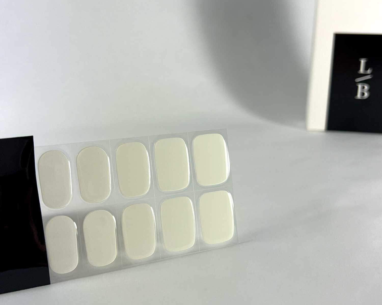 storm white grey semi-cured gel nails in black light sensitive strip with la-bek uv lamp box in the background