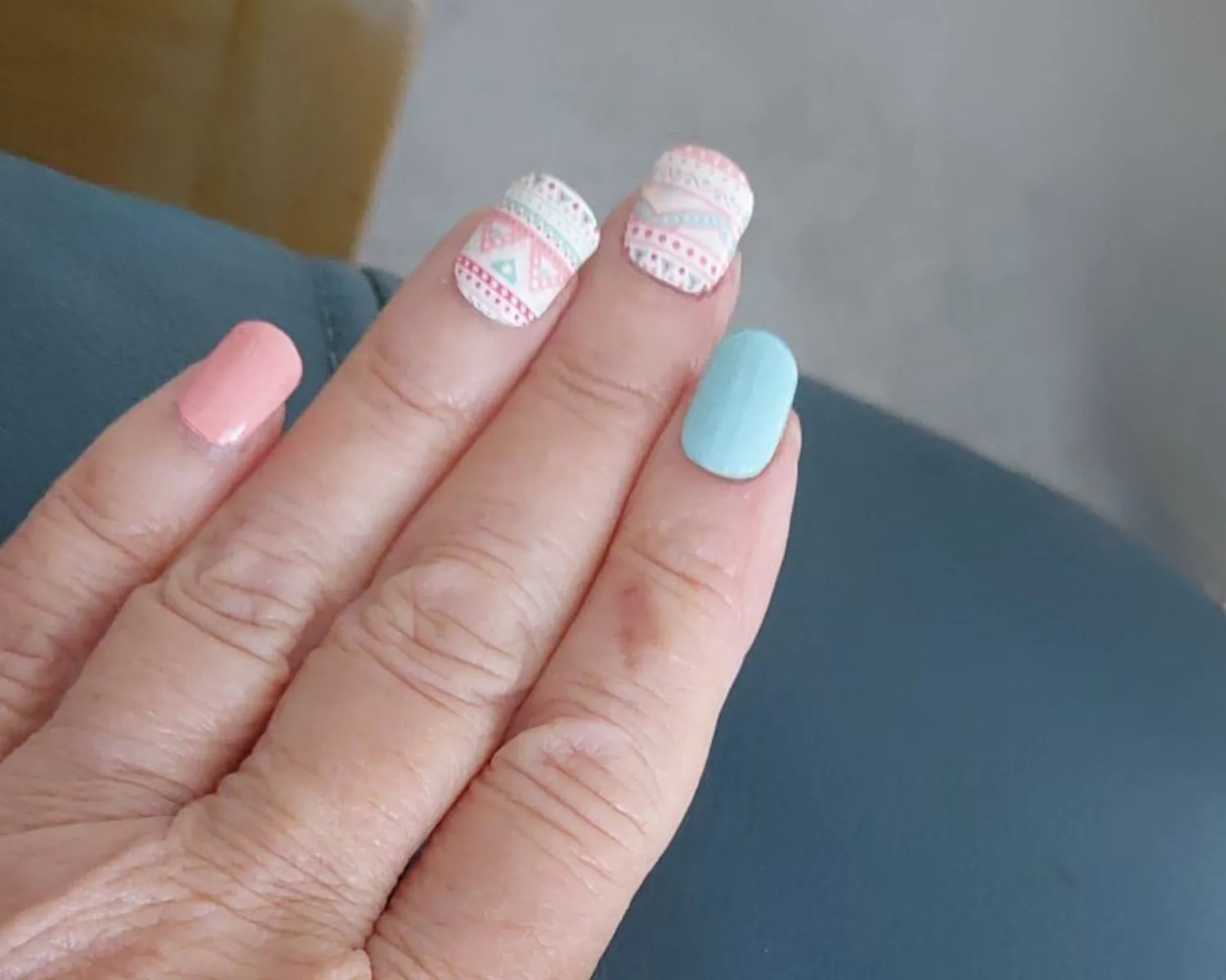 Semi-cured gel nail wraps in teal chrome on customers hand